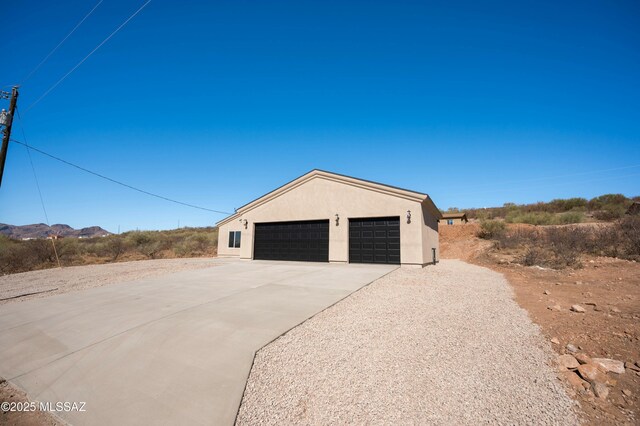 view of front of house with driveway, an attached garage, and stucco siding