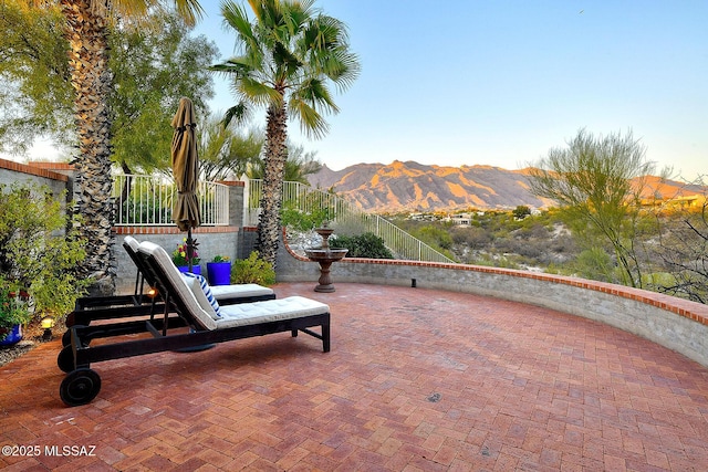 view of patio featuring fence and a mountain view