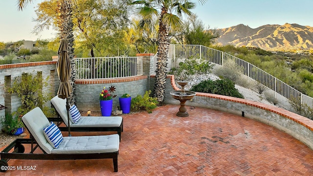 view of patio featuring fence and a mountain view