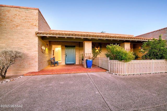 view of front of home featuring a tile roof and fence