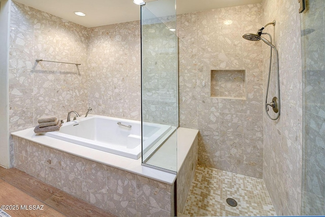 bathroom featuring tile walls, a tile shower, and a bath