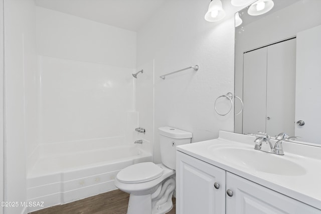 bathroom featuring toilet,  shower combination, wood finished floors, and vanity