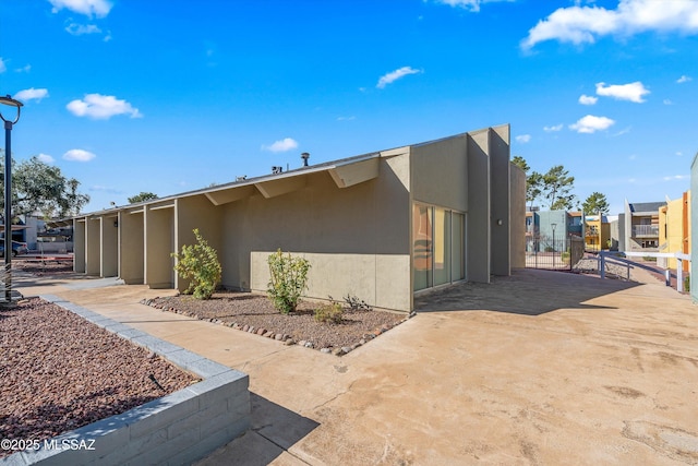 view of home's exterior with fence and stucco siding