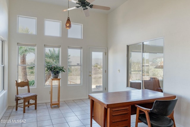 office featuring light tile patterned floors, a high ceiling, and baseboards