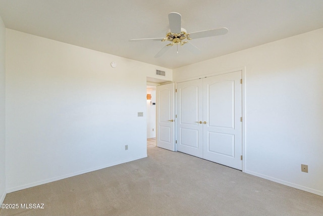 unfurnished bedroom with baseboards, visible vents, a closet, and light colored carpet