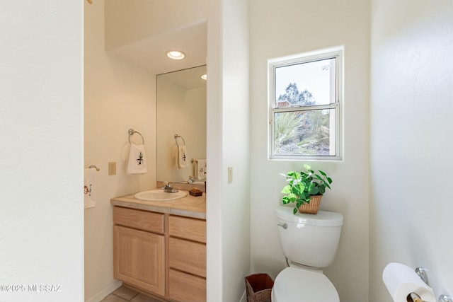 half bathroom featuring toilet, vanity, and recessed lighting