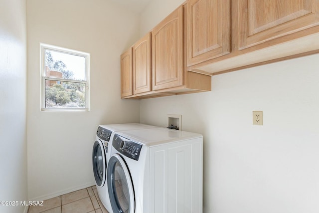 laundry room with light tile patterned flooring, washing machine and clothes dryer, cabinet space, and baseboards