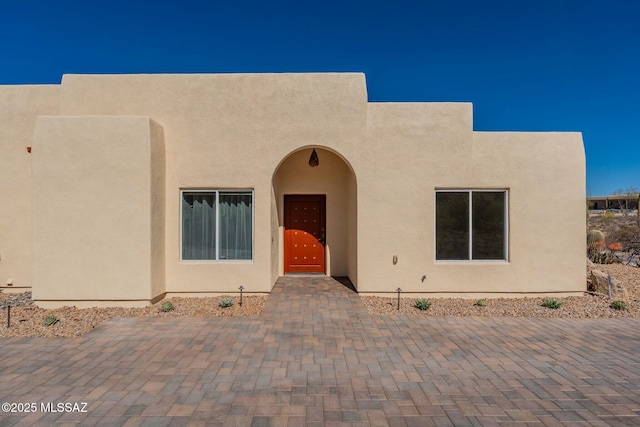 pueblo-style home featuring stucco siding