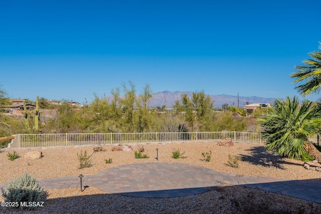 view of yard with a fenced backyard, a mountain view, and a patio