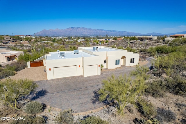 view of front of property featuring driveway, a mountain view, and stucco siding