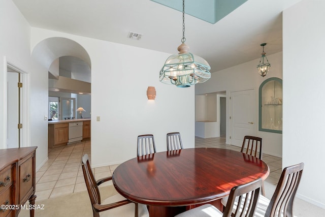 dining space featuring arched walkways, light tile patterned floors, visible vents, and baseboards