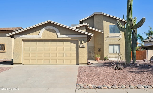 view of front of property with driveway, an attached garage, and stucco siding