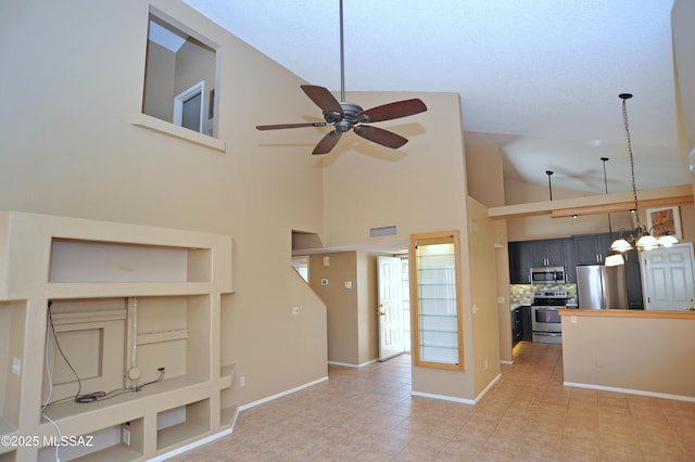 kitchen featuring ceiling fan with notable chandelier, stainless steel appliances, butcher block counters, baseboards, and backsplash