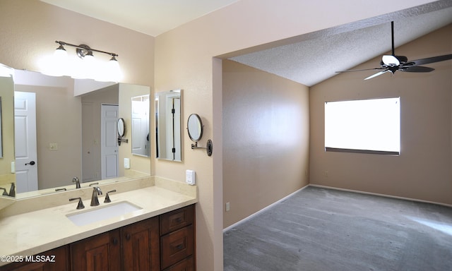 bathroom featuring lofted ceiling, ceiling fan, vanity, a textured ceiling, and baseboards