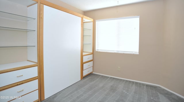 interior space with baseboards and light colored carpet