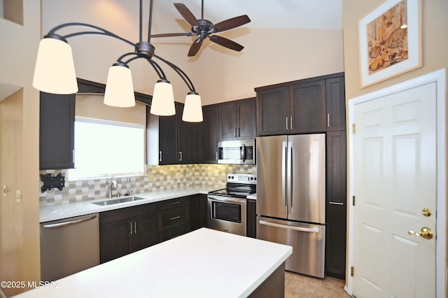 kitchen with dark brown cabinetry, stainless steel appliances, a sink, light countertops, and backsplash