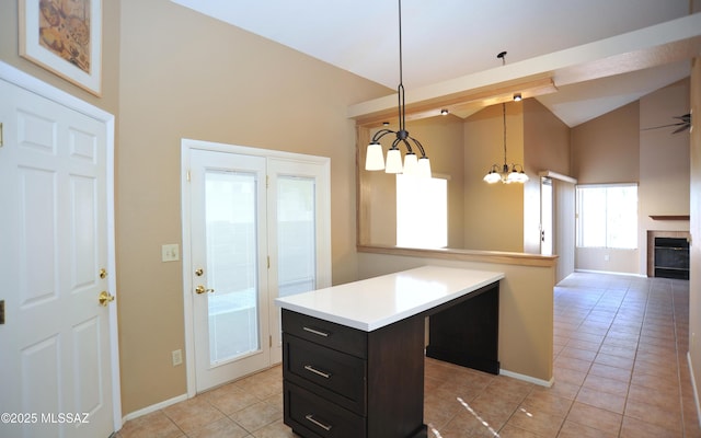 kitchen with light tile patterned floors, open floor plan, a center island, light countertops, and pendant lighting