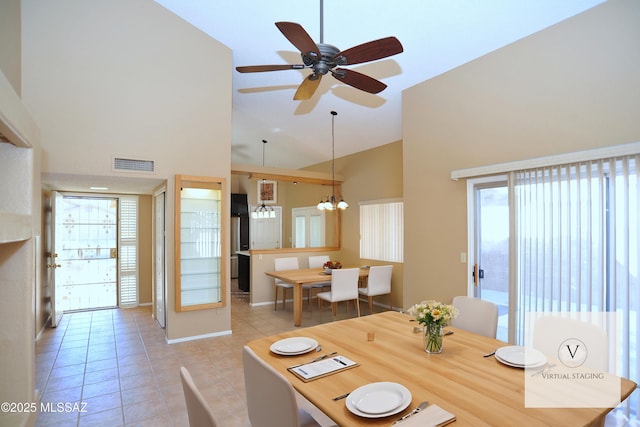 dining room featuring light tile patterned floors, high vaulted ceiling, ceiling fan with notable chandelier, and visible vents