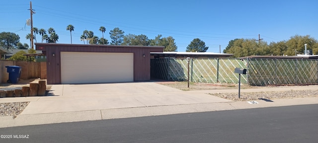 view of front of home with a garage, driveway, an outbuilding, and fence