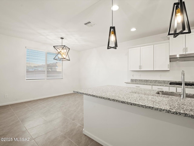 314 N Pecan Pie Pl, Sahuarita, AZ 85629 - kitchen with recessed lighting, under cabinet range hood, visible vents, decorative light fixtures, and white cabinetry