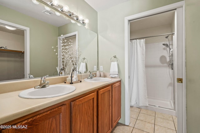 full bathroom featuring a stall shower, tile patterned flooring, and a sink