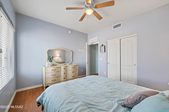 bedroom featuring a closet, visible vents, baseboards, and wood finished floors