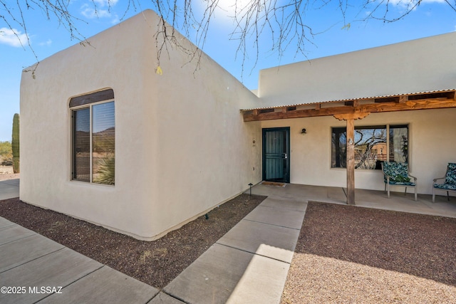 exterior space with a patio and stucco siding