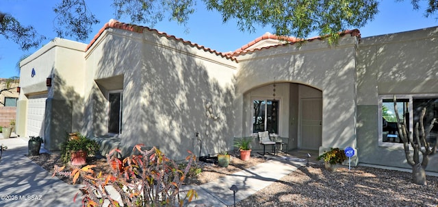 back of house with a garage and stucco siding