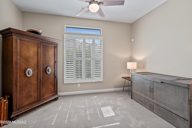 interior space featuring a ceiling fan, light colored carpet, and baseboards