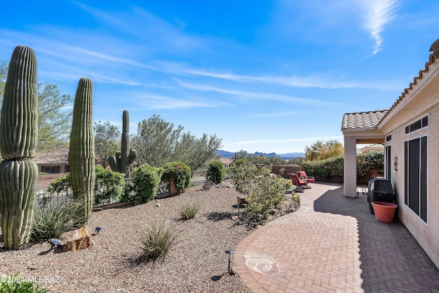 view of yard featuring a patio area, a fenced backyard, and a mountain view