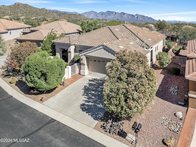 view of front facade with a residential view, a tile roof, driveway, and a mountain view