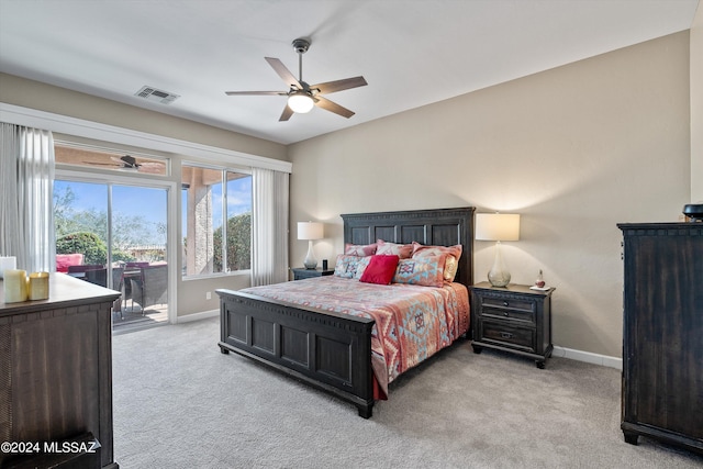 bedroom with access to outside, visible vents, light carpet, and baseboards