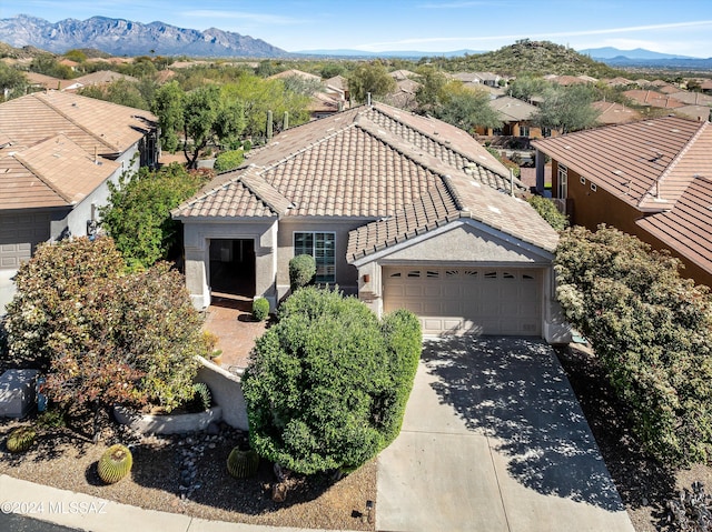 view of front of property with a garage, a tiled roof, concrete driveway, and a mountain view