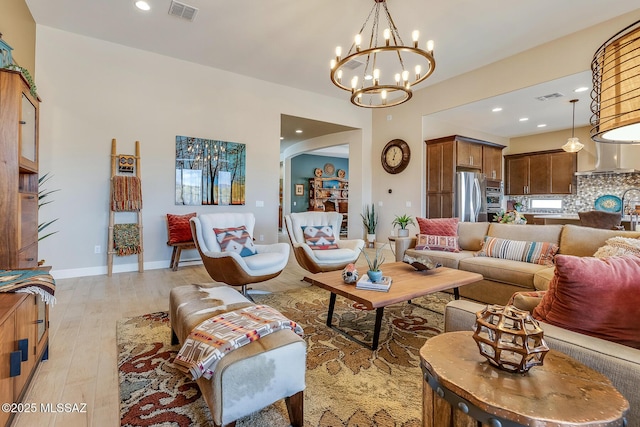 living room featuring light wood-type flooring, arched walkways, visible vents, and baseboards