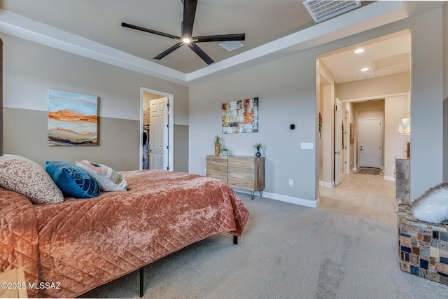 carpeted bedroom featuring a spacious closet, a tray ceiling, visible vents, and baseboards