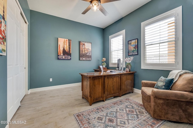 home office featuring light wood-type flooring, ceiling fan, and baseboards