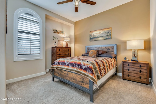 carpeted bedroom with ceiling fan and baseboards