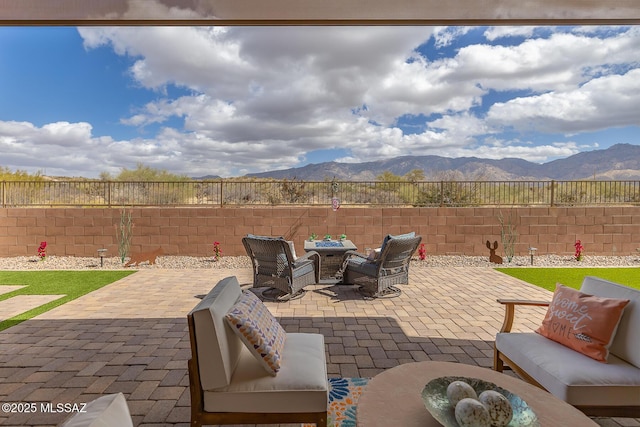 view of patio featuring an outdoor hangout area, fence private yard, and a mountain view