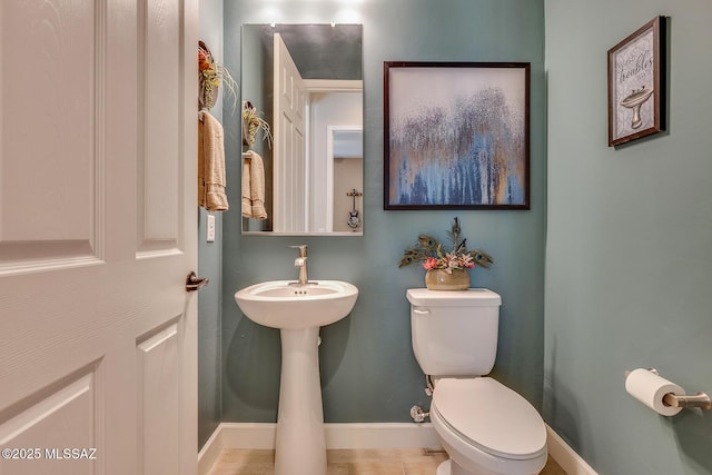 bathroom featuring baseboards and toilet