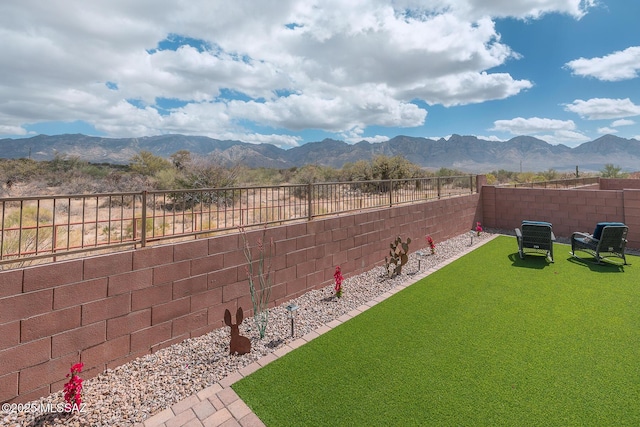 view of yard with a fenced backyard and a mountain view