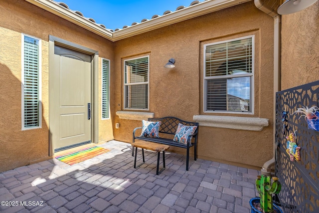 property entrance with a patio area and stucco siding