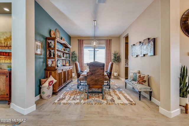 dining area with baseboards, visible vents, and wood finished floors