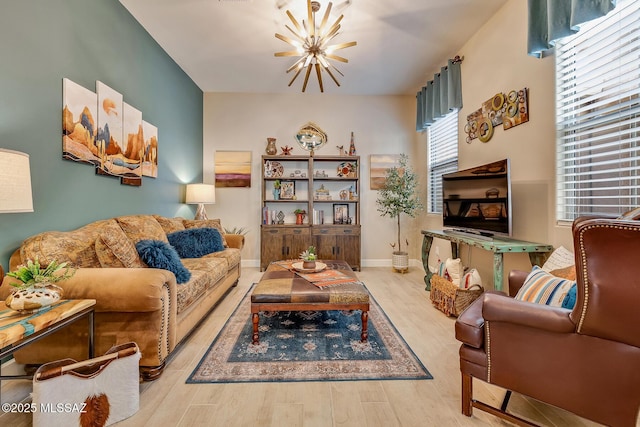 living room with a notable chandelier, baseboards, and wood finished floors