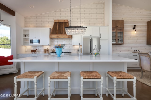 kitchen with white cabinets, stainless steel appliances, custom exhaust hood, and light countertops