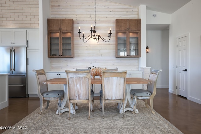 kitchen with light countertops, high quality fridge, glass insert cabinets, and decorative light fixtures