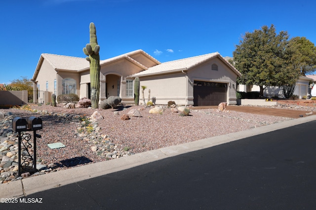 ranch-style home with a garage, stucco siding, and a tiled roof