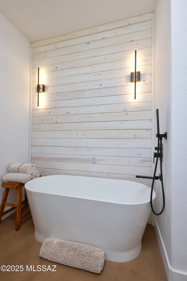 bathroom with a soaking tub and wooden walls