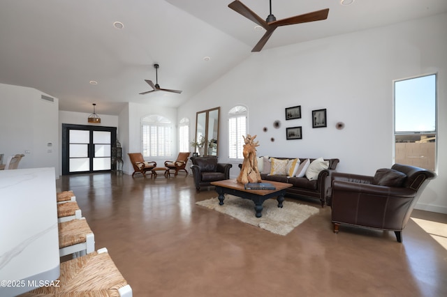 living room with ceiling fan, high vaulted ceiling, visible vents, and concrete flooring