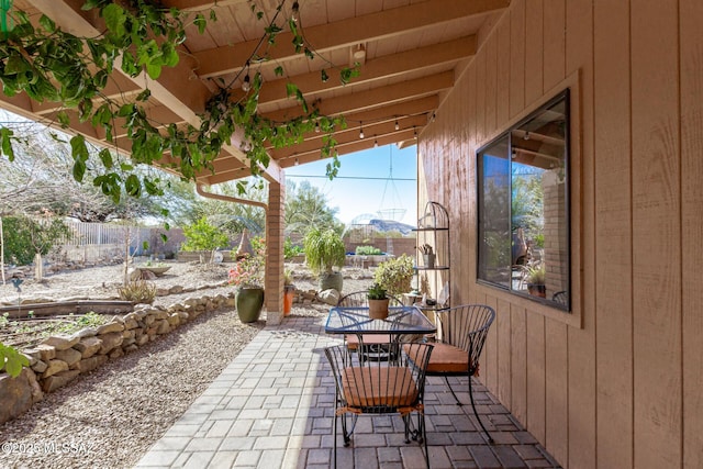 view of patio featuring outdoor dining space and fence