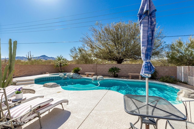 view of swimming pool featuring a patio area, a fenced backyard, and a mountain view